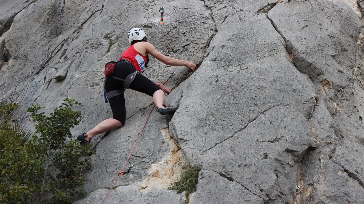 A climber ascends a rugged cliff face in El Chorro, Andalusia, Spain, capturing adventure and skill.
